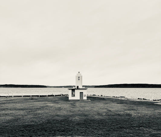 Black and white photo of a lighthouse in a field